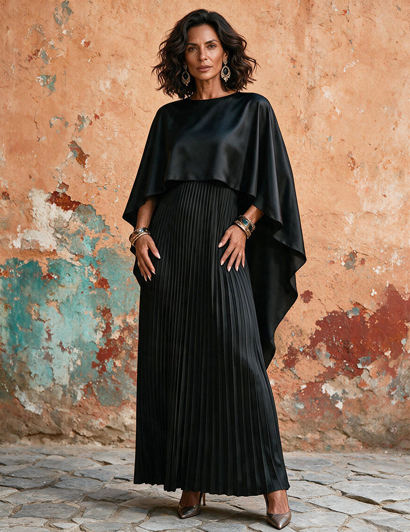 Black pleated maxi dress with batwing cape sleeves and draped asymmetrical hem