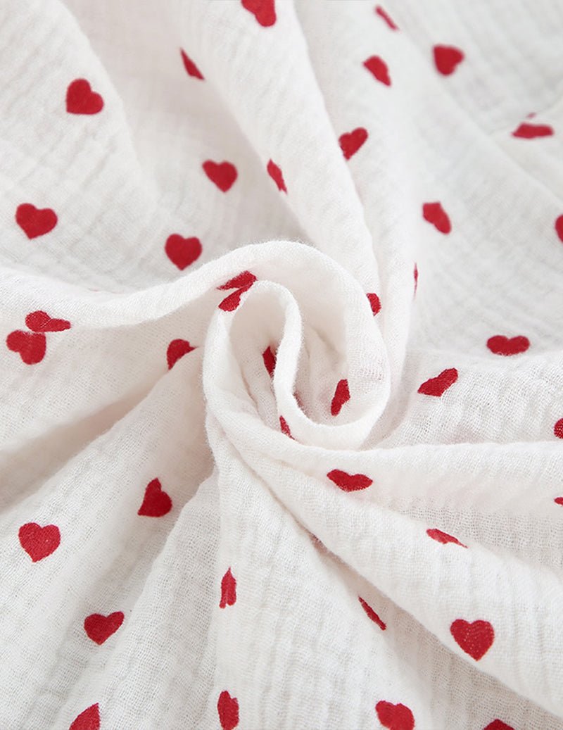 White cotton fabric with red cherry-heart print and sheer textured weave