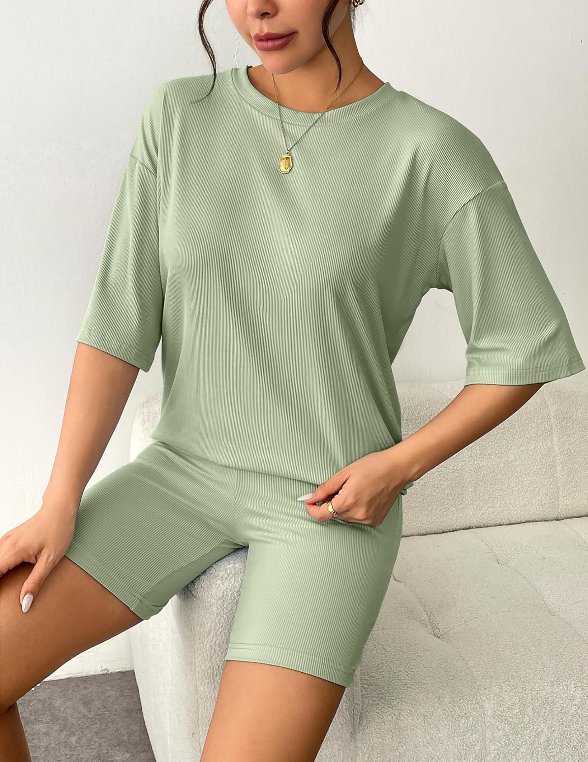 Light green ribbed knit lounge set with short-sleeve T-shirt and matching shorts, seated front view