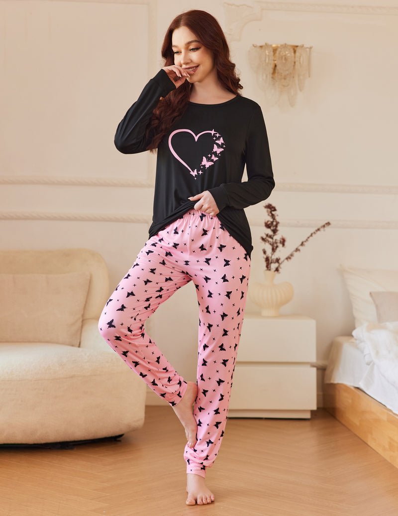 Black long-sleeve pajama top with pink heart graphic and pink patterned joggers