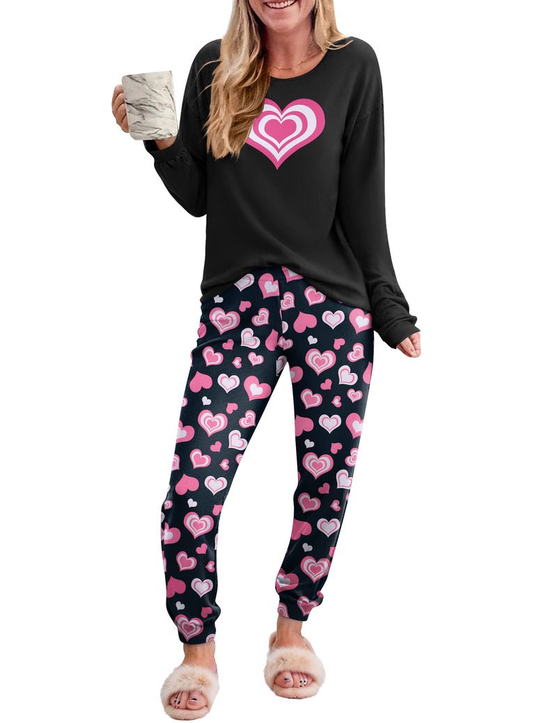 Black long-sleeve pajama set with pink heart graphic and black pants with pink hearts