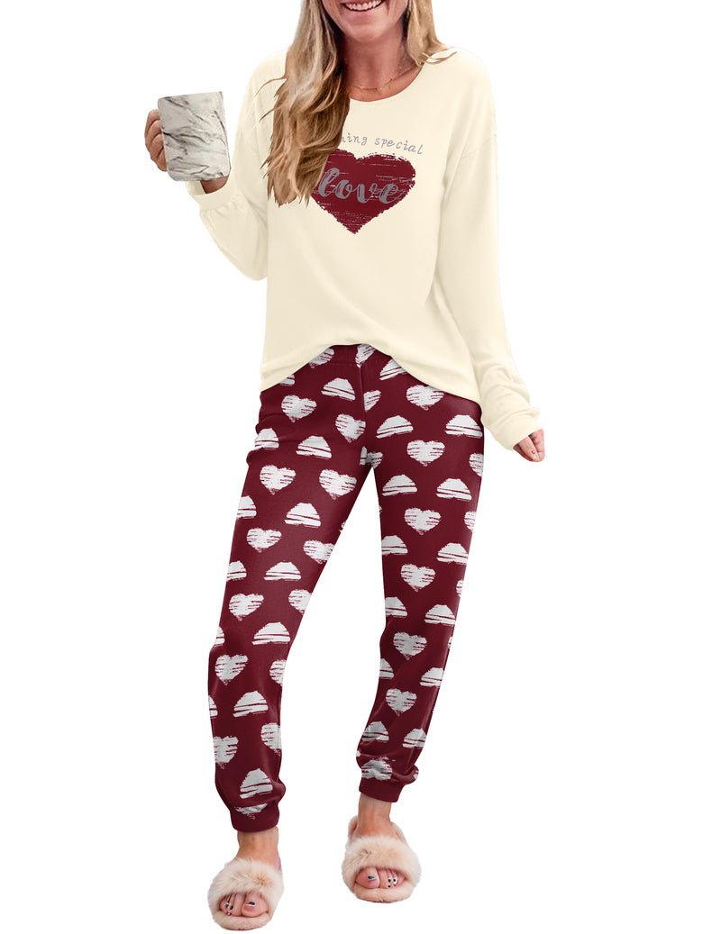 Cream long-sleeve pajama top with red heart graphic and red patterned joggers