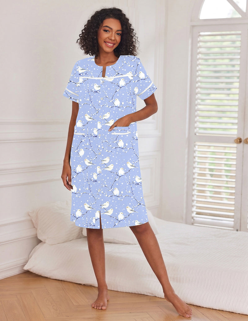 Light blue button-down house dress with short sleeves and pockets, curved neckline, side slit