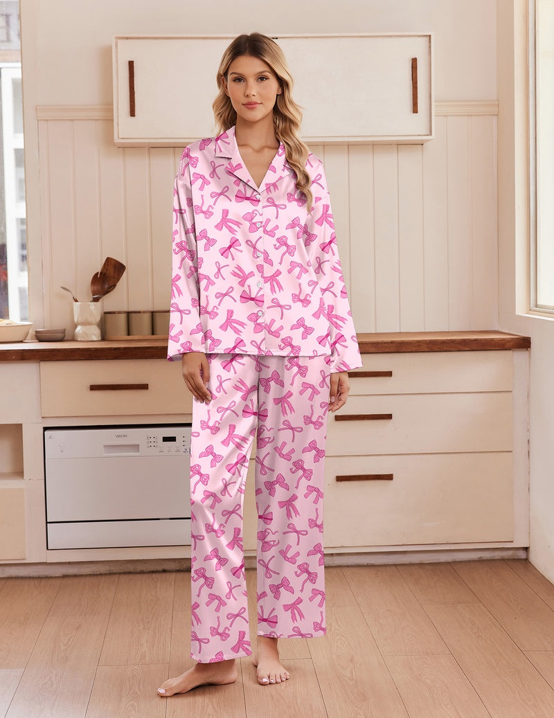 Pink satin pajama set with notch collar, button front, and long-sleeve matching pants with print