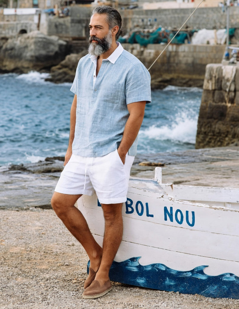 Light blue short-sleeve camp shirt with white drawstring shorts, side