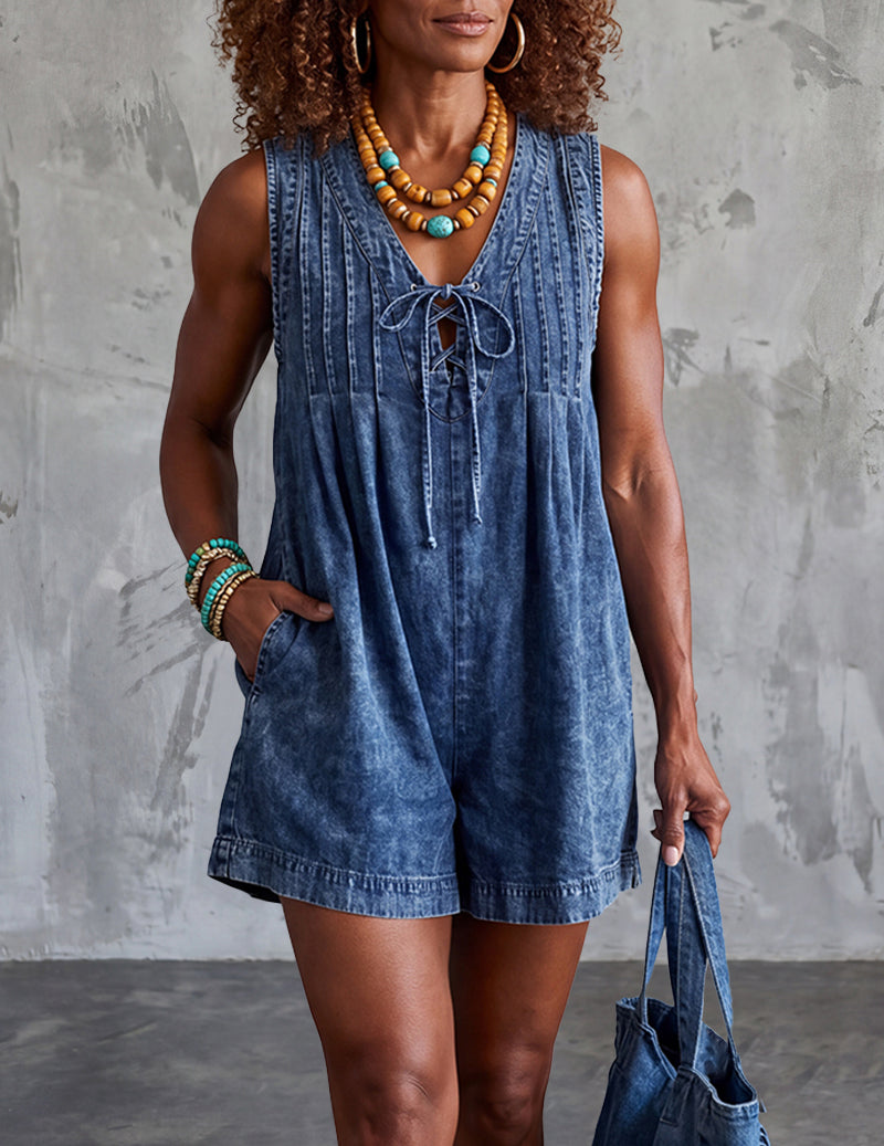 Light blue denim sleeveless romper with V neckline, lace-up front, and side pockets