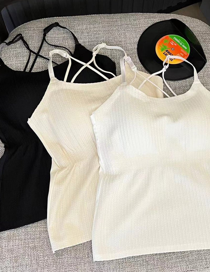 Cream adjustable spaghetti strap camisoles with crisscross back straps and textured knit