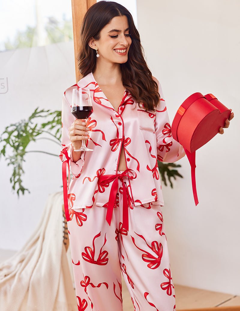 Long satin button-down pajama set in white with red bow pattern, front buttons