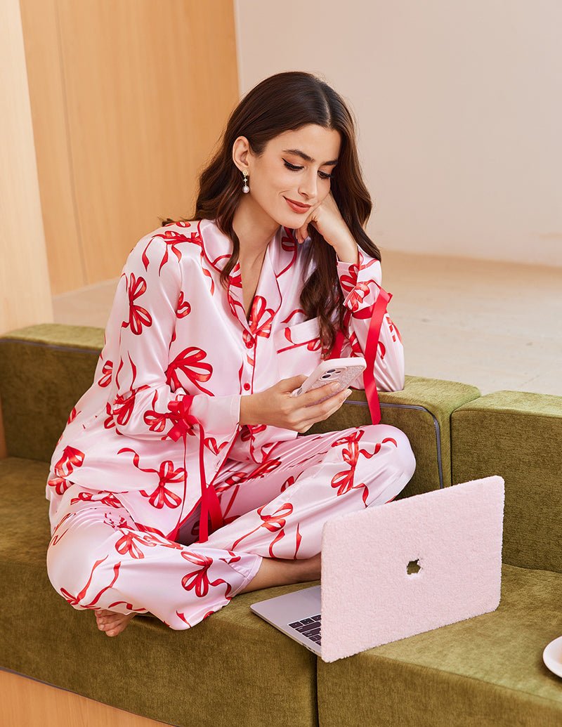 White satin pajama set with red bow print, button front and tie belt, long sleeves