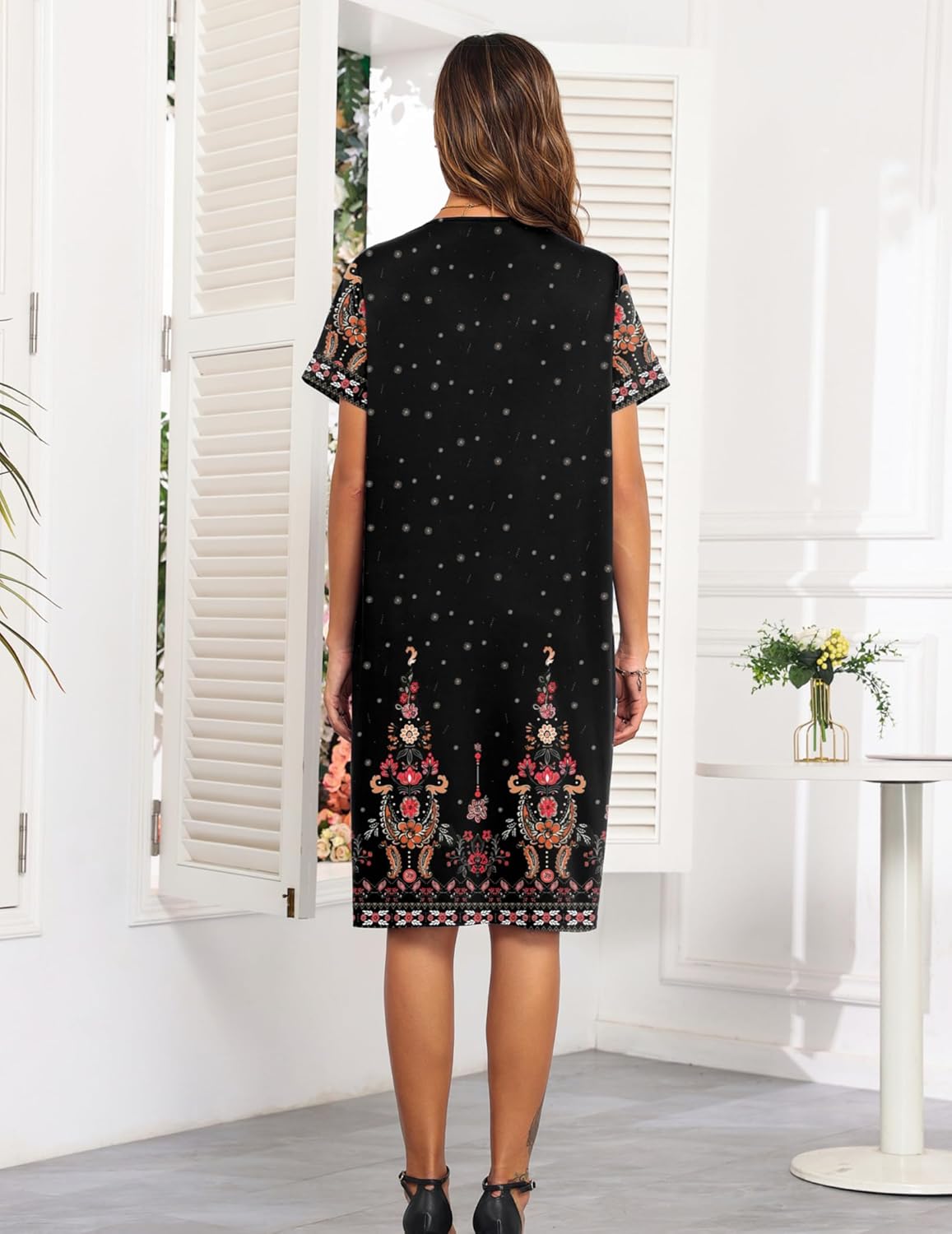 Back view of black button-down nightgown dress with short sleeves and floral hem