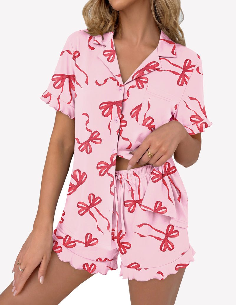Pink pajama set with red bow print: button-up short sleeve top and ruffle shorts
