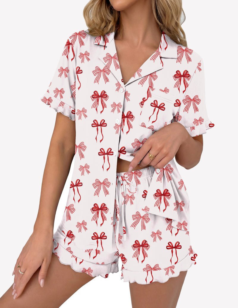 White pajama set with red bow print: button-up short sleeve top and ruffle shorts