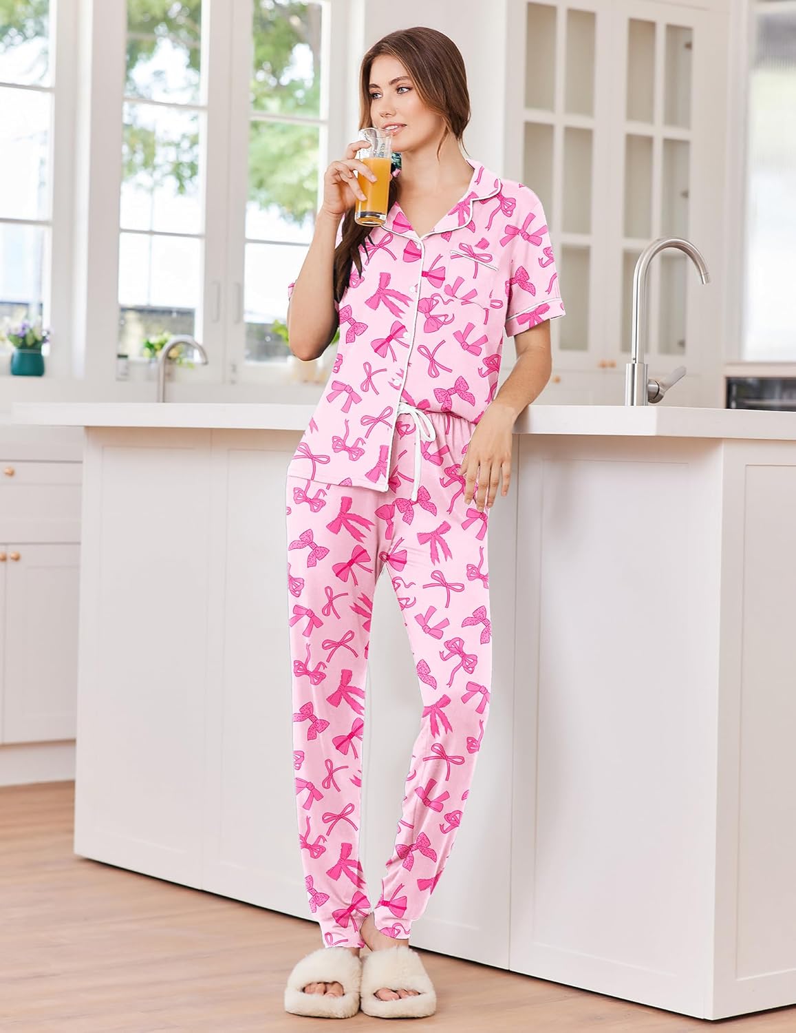 Women's button-front pajama set in light pink with bow print, white trim, drawstring joggers