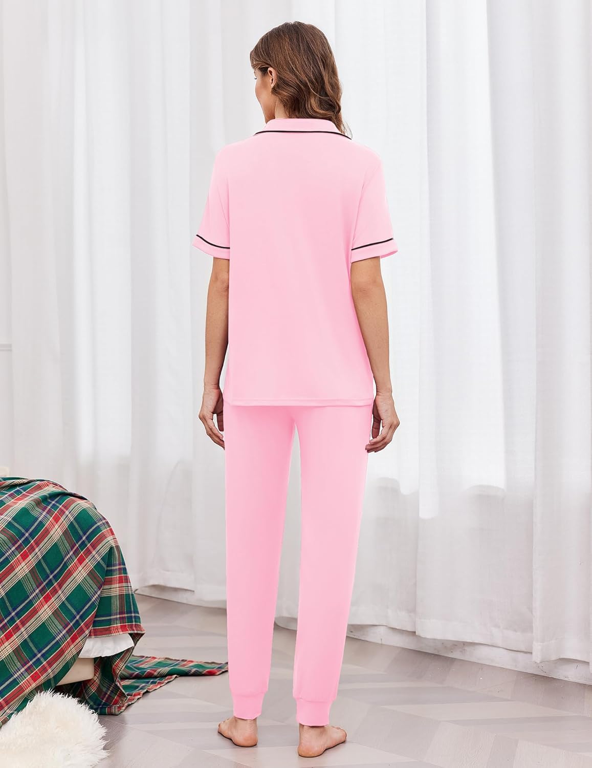 Women's back view light pink button-front pajama set with white trim and drawstring joggers