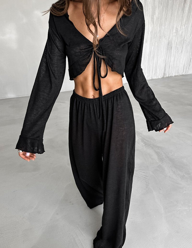 Black two-piece pajama set with tie-front long-sleeve crop top and wide-leg pants