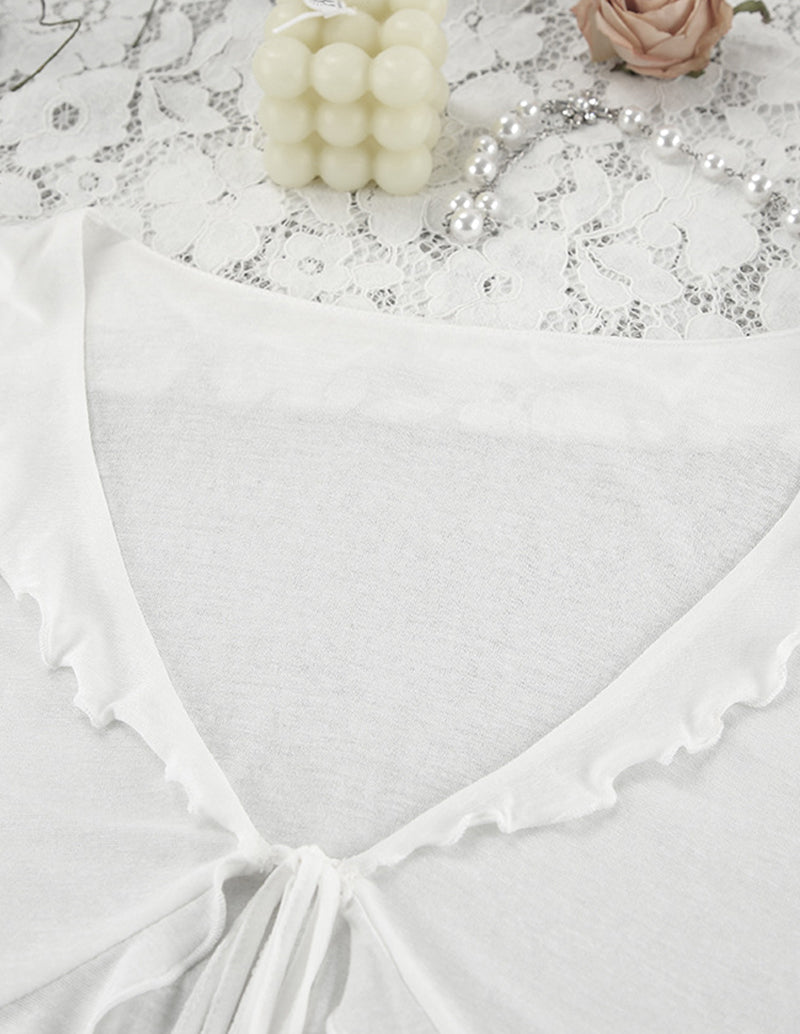 White pajama top with ruffled trim and drawstring tie at the neckline