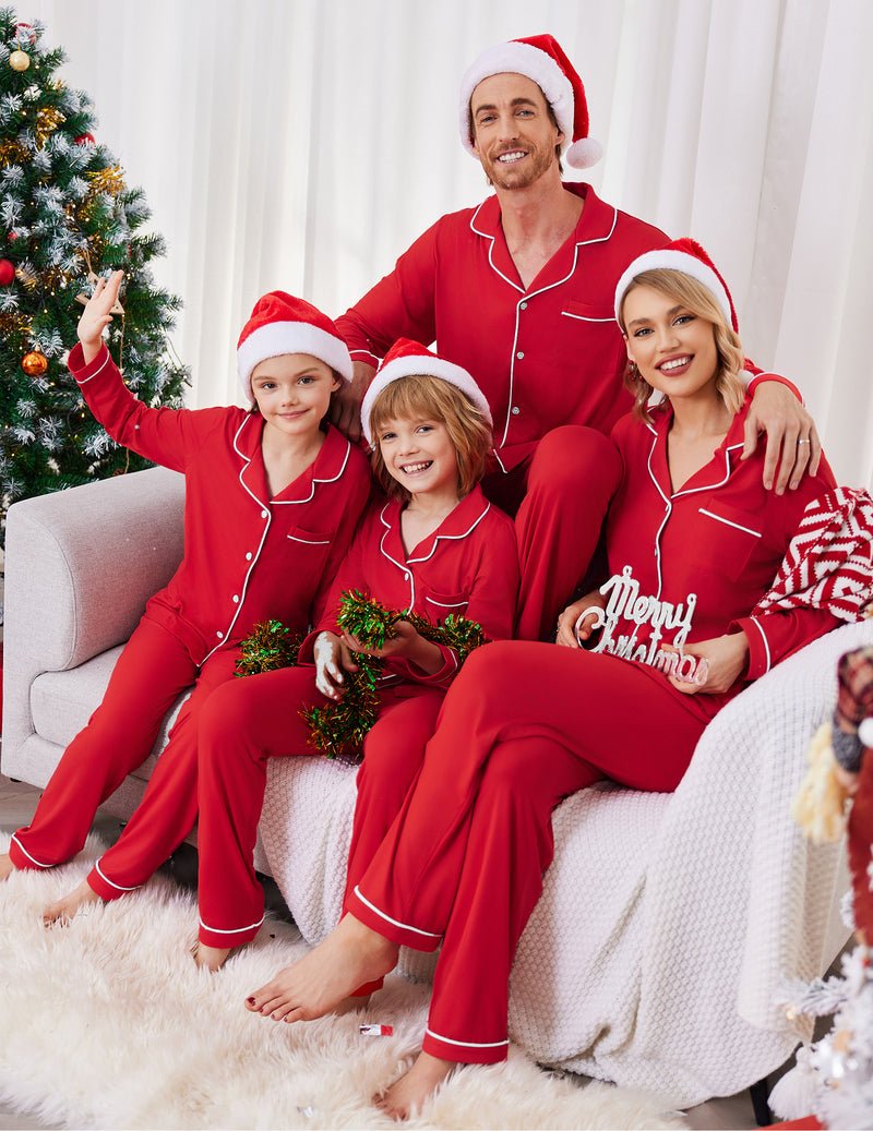 Red long-sleeve family pajama set with white piping and matching Santa hats