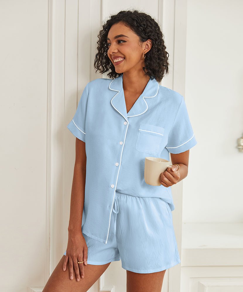 Light blue short-sleeve pajama set with button front, piped collar, and drawstring shorts.