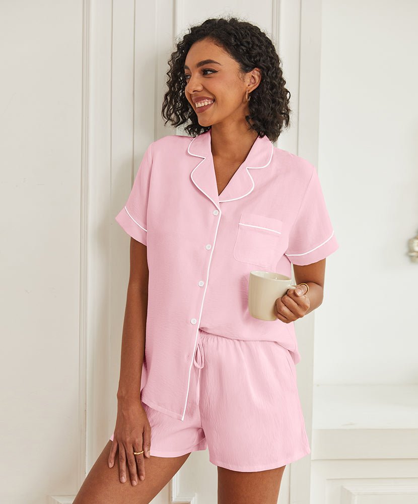 Light pink short-sleeve pajama set with button front, piped collar, and drawstring shorts.