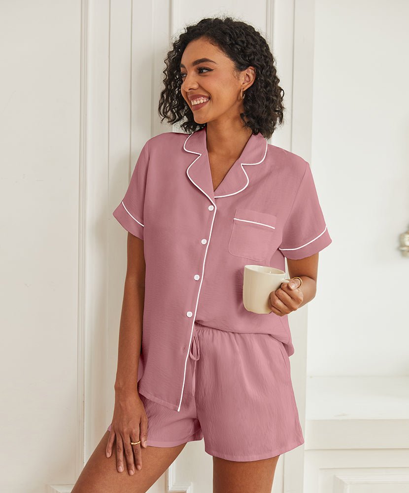 Pink short-sleeve pajama set with button front, piped collar, and drawstring shorts.