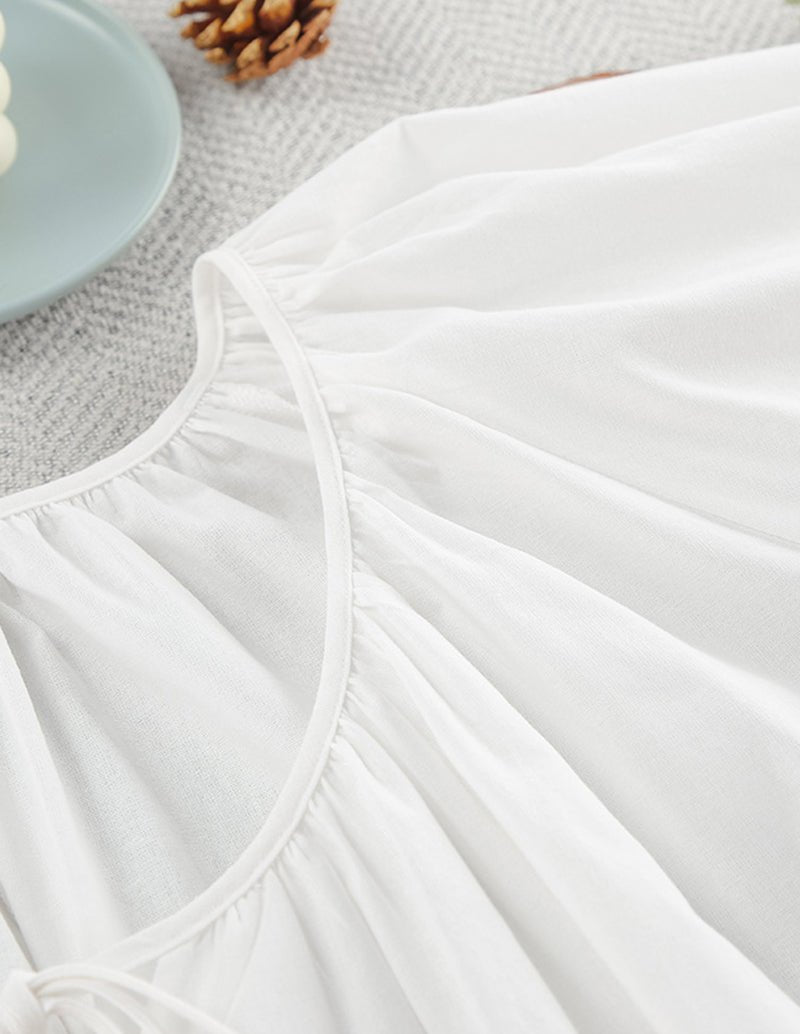 White cotton nightgown close-up of curved neckline and gathered bodice seam