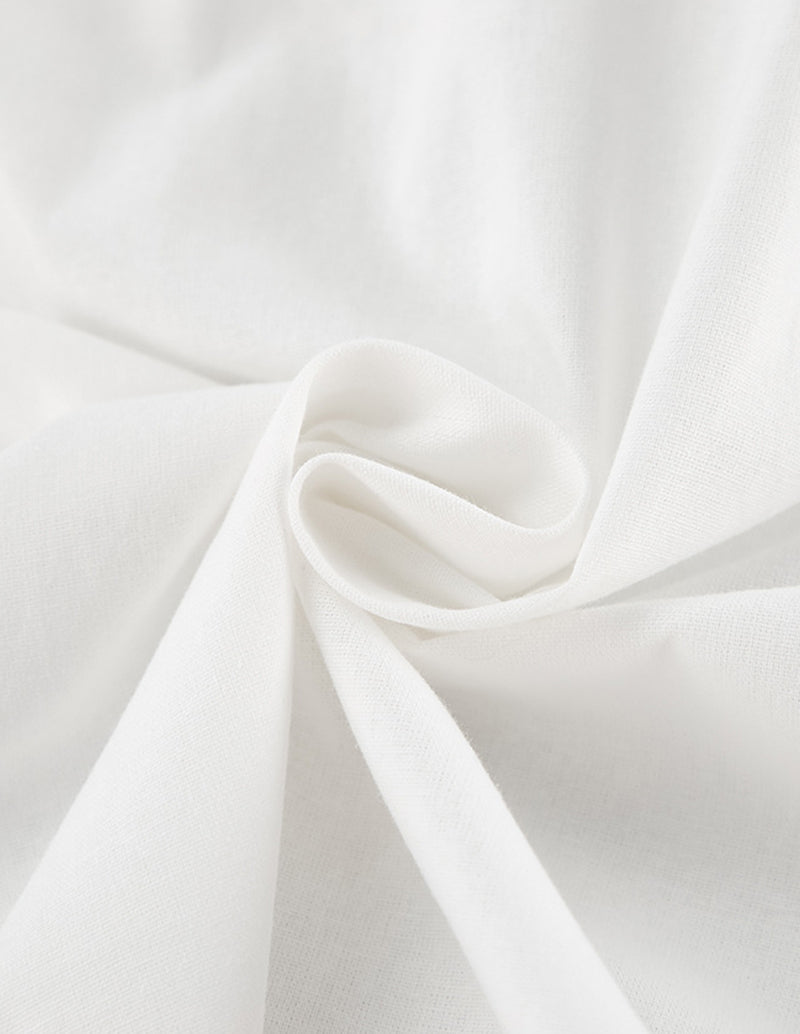 White cotton nightgown fabric close-up with soft gathered drape