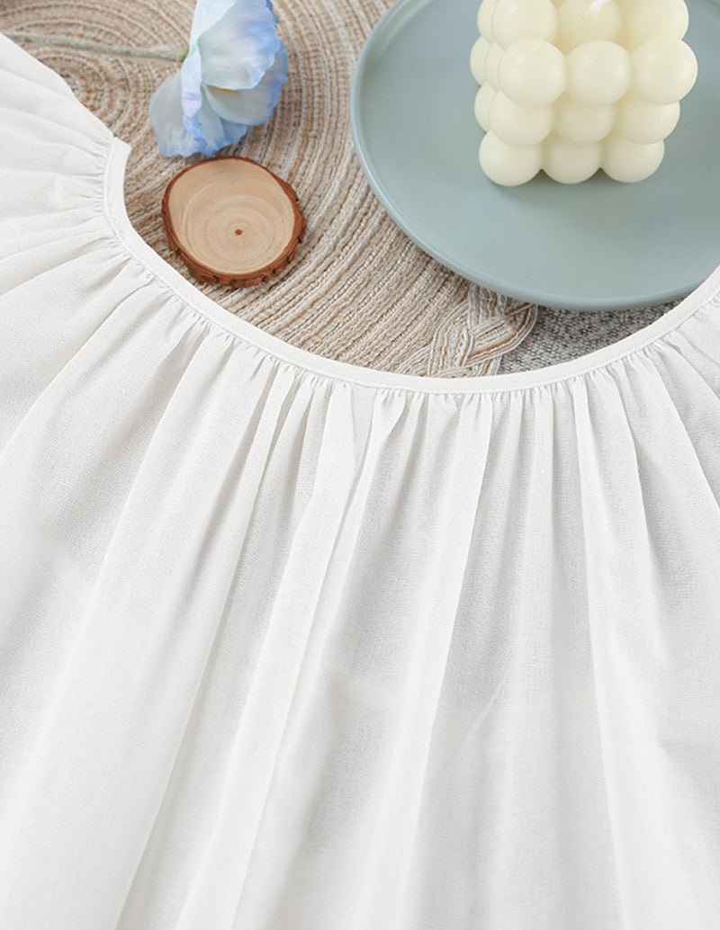 White cotton nightgown close-up of gathered neckline with pleated front panel