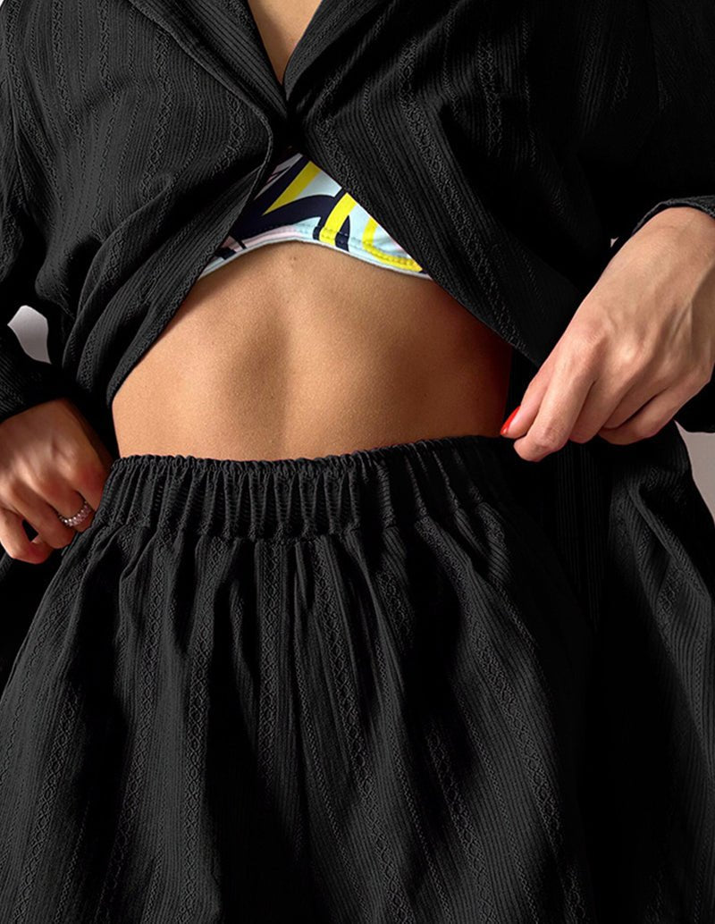 Black cotton jacquard shorts with elastic waist, paired with a button shirt