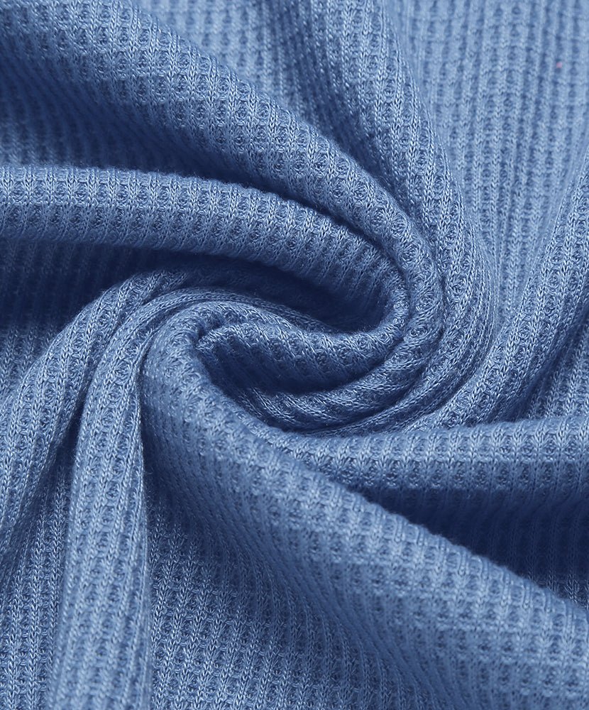Waffle knit pajama fabric close-up in blue with textured knit pattern