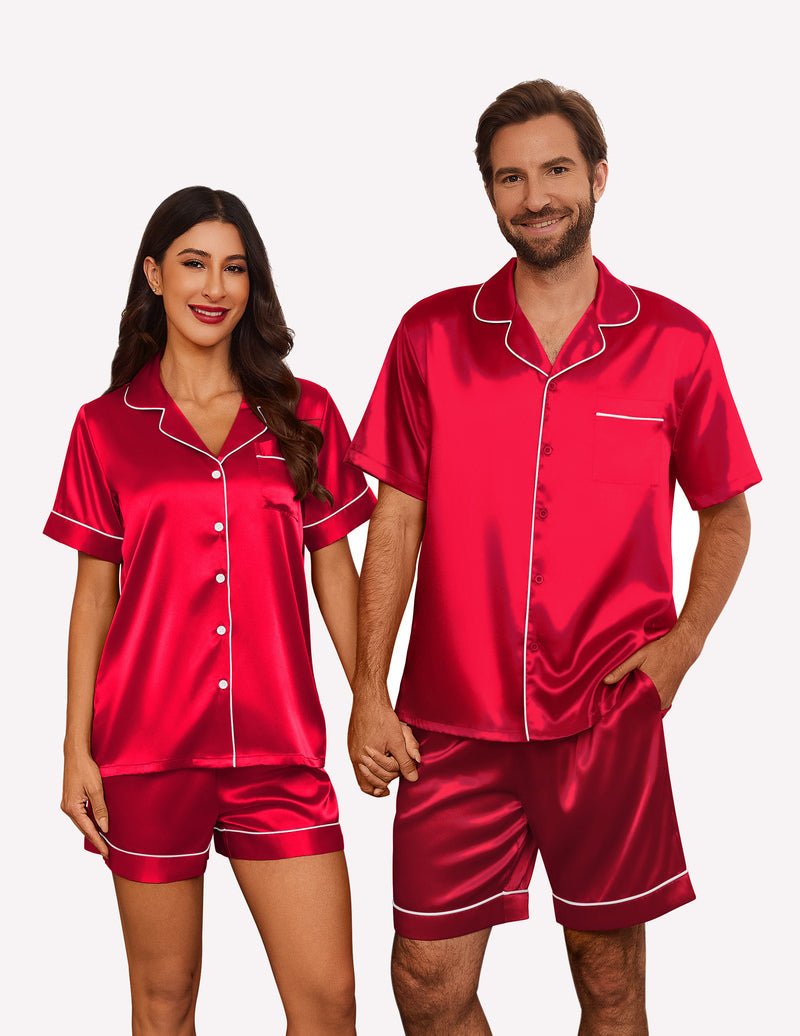 Red satin pajama set for couples: short-sleeve button shirt and matching shorts, white piping.
