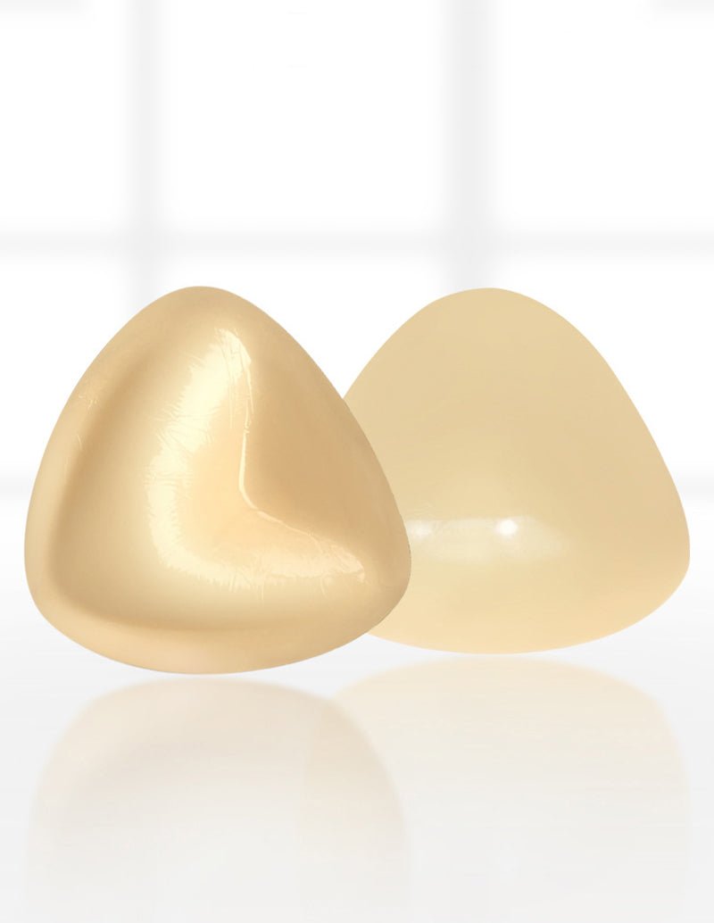 Self-adhesive chest pad pair, glossy cream triangular cups.