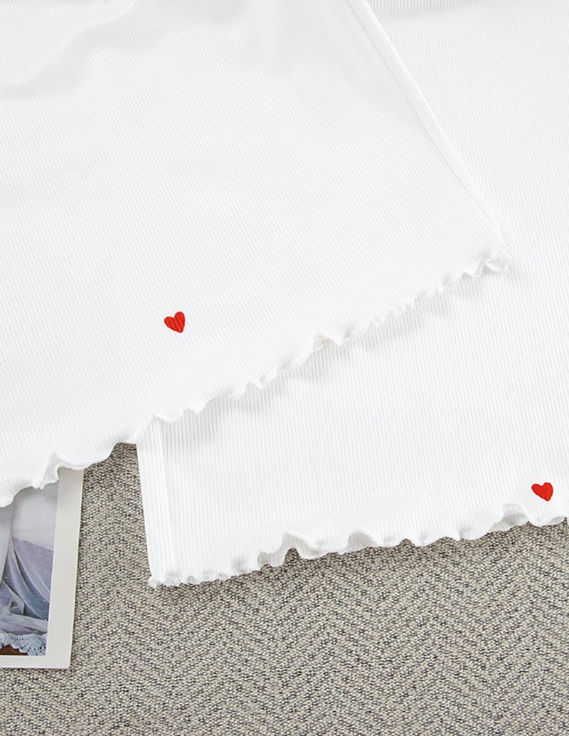 White lounge shorts with red heart accents and scalloped ruffle hem