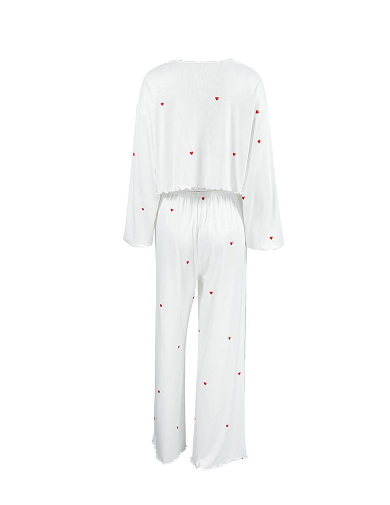 White lounge set with long-sleeve top and wide-leg pants, red heart print, back view.