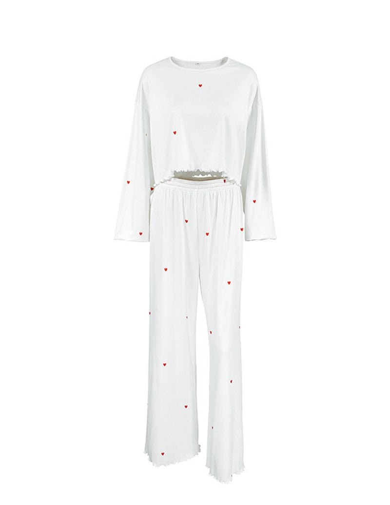 White two-piece lounge set with long sleeves and wide-leg pants, red heart print.