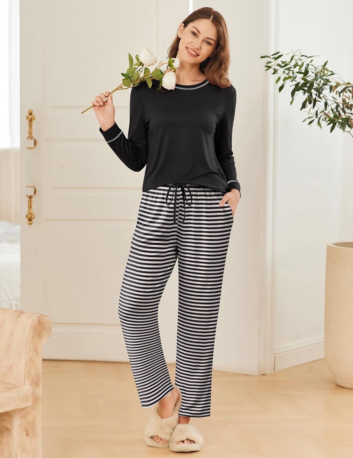 Black long-sleeve pajama top with black-and-white striped pants, drawstring waist.