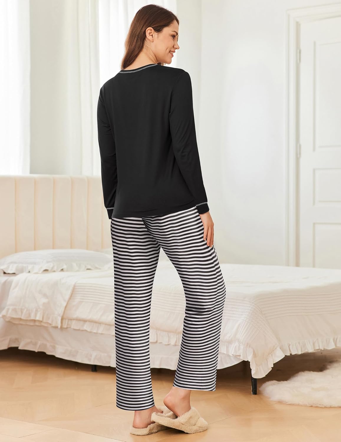 Back view of black long-sleeve pajama top with black-and-white striped pants.