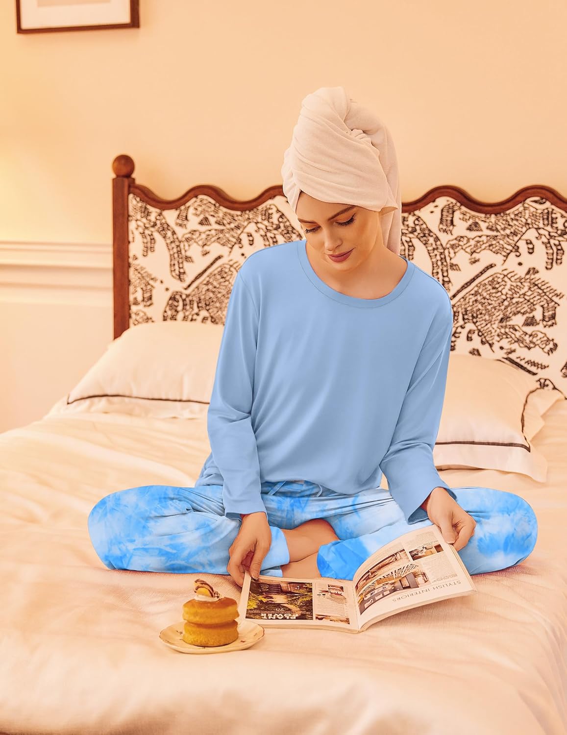 Light blue long-sleeve pajama set with blue tie-dye print pants, seated view