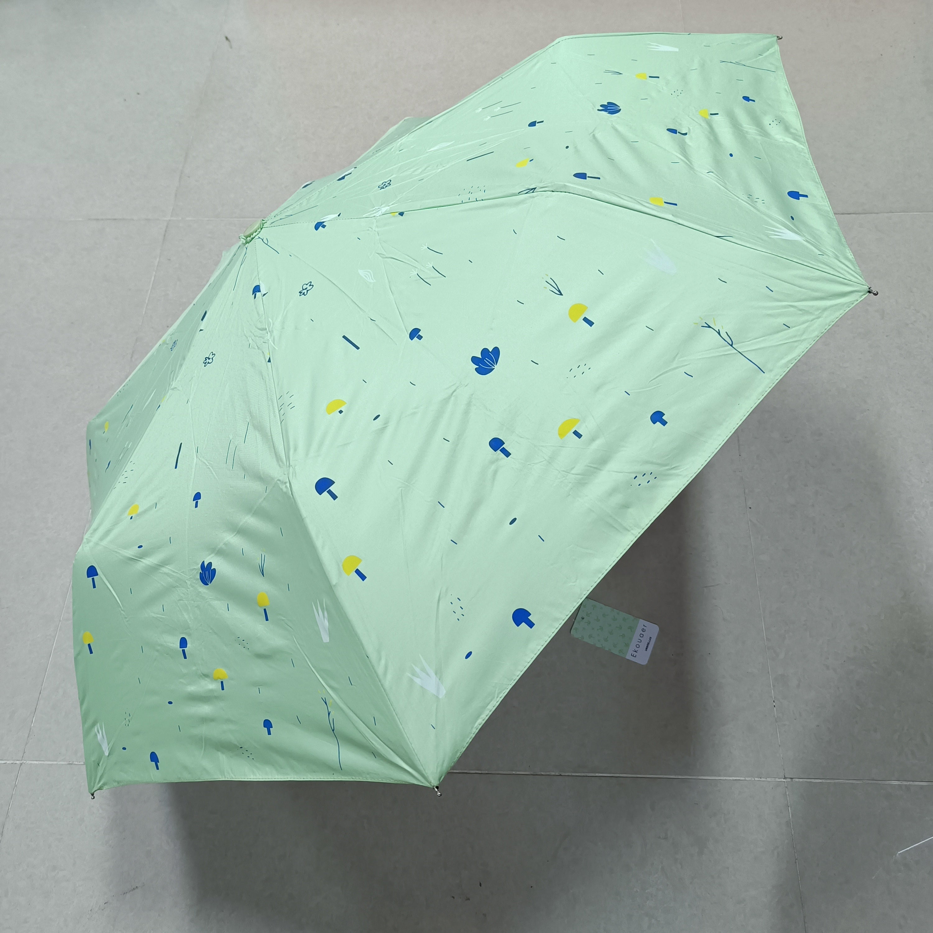 Green canopy umbrella with small blue and yellow graphics
