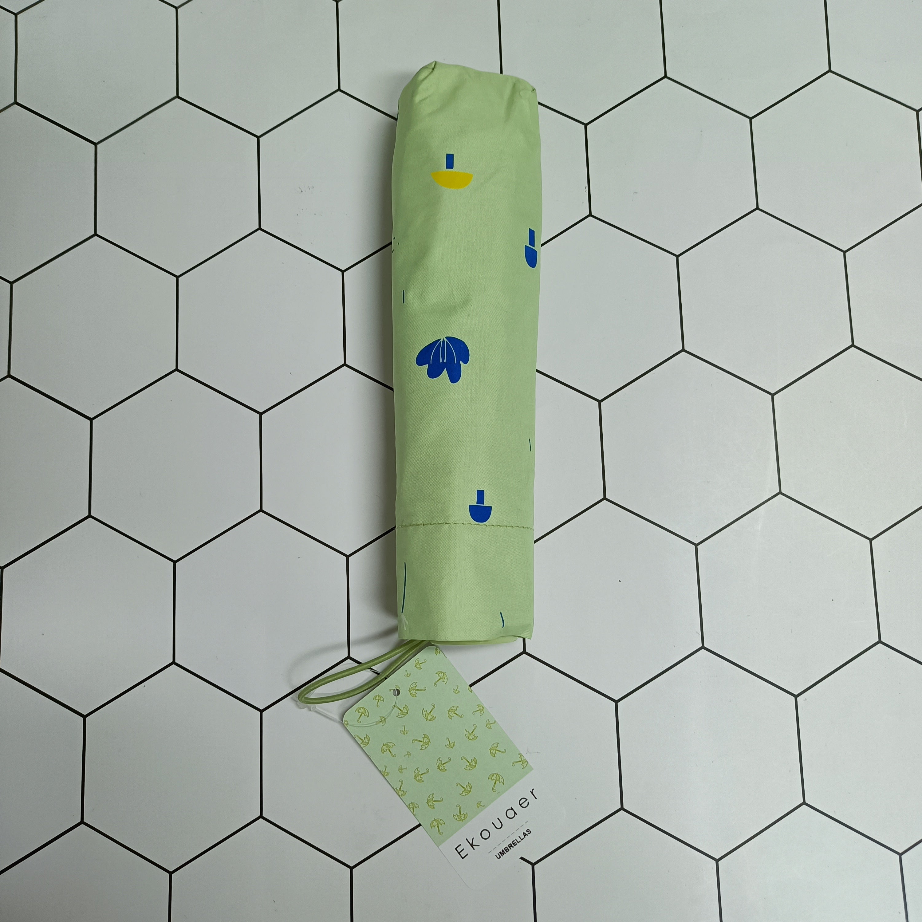 Green umbrella storage sleeve with cartoon icons and hanging Ekouaer tag