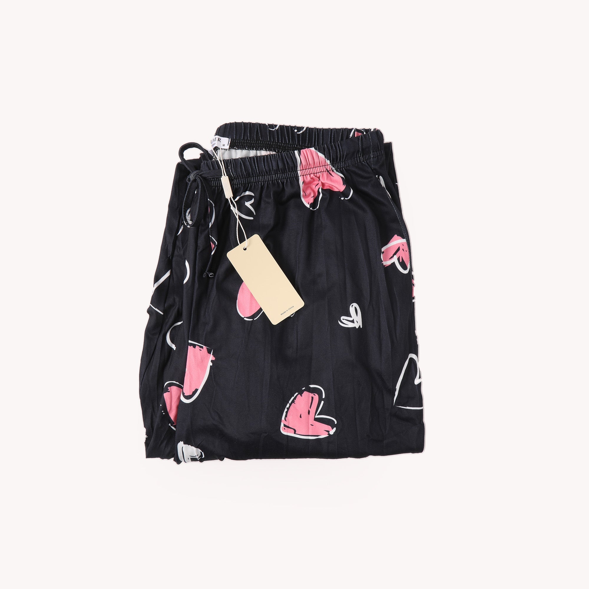 Black heart-printed pants with elastic waist, drawstring, and hanging tag