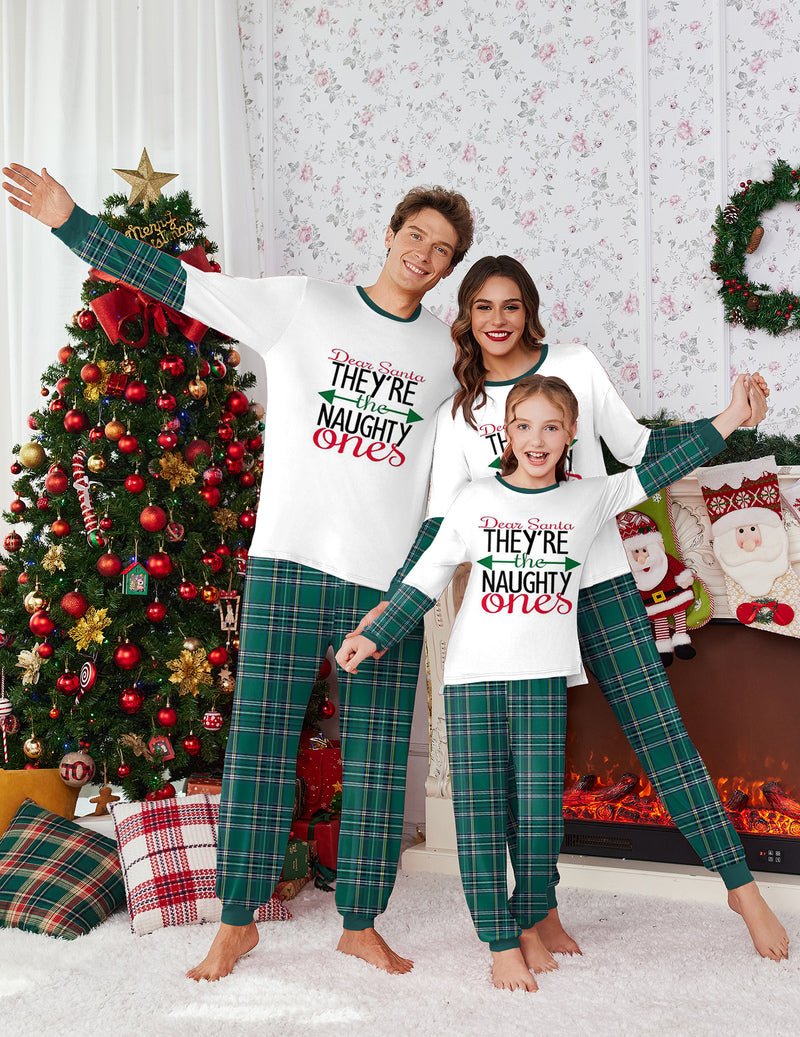 White top with “They’re the Naughty Ones” print and green plaid pajama pants, kids set