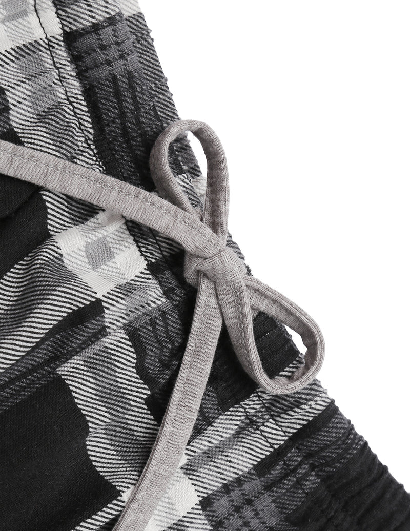 Close-up of grey-and-black plaid pajama fabric with tied drawstring waistband