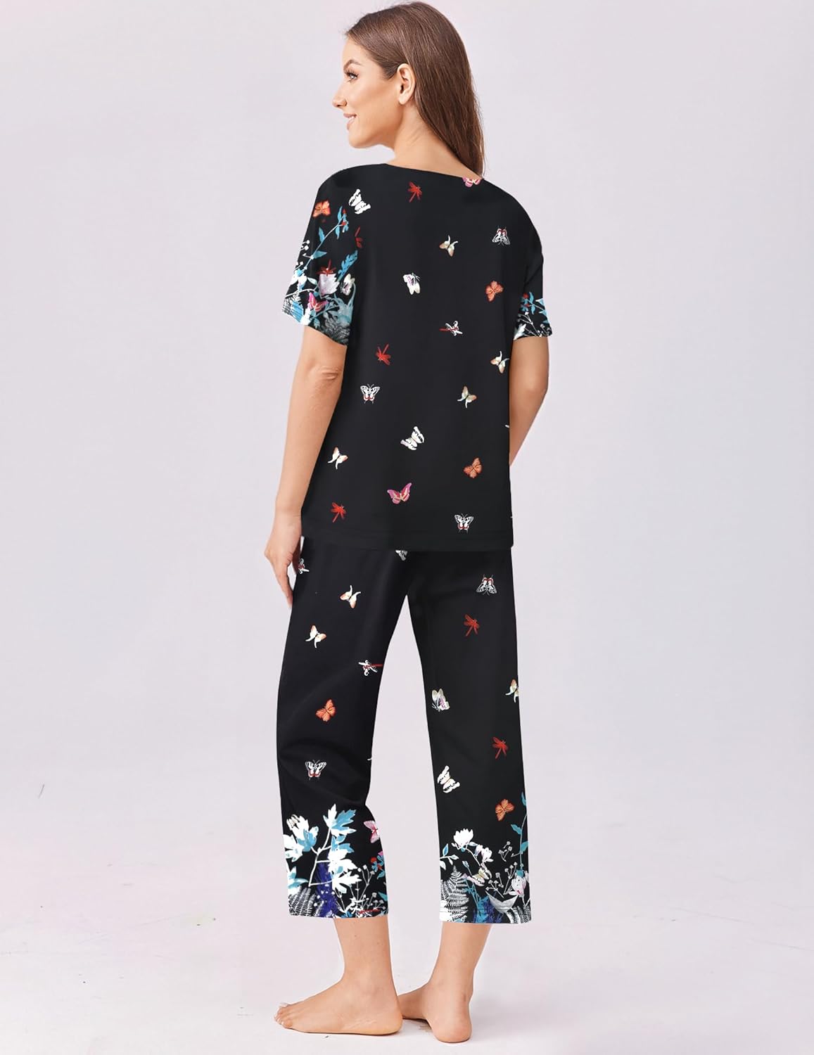 Black pajama top and capri pants set with colorful scattered animal and floral print