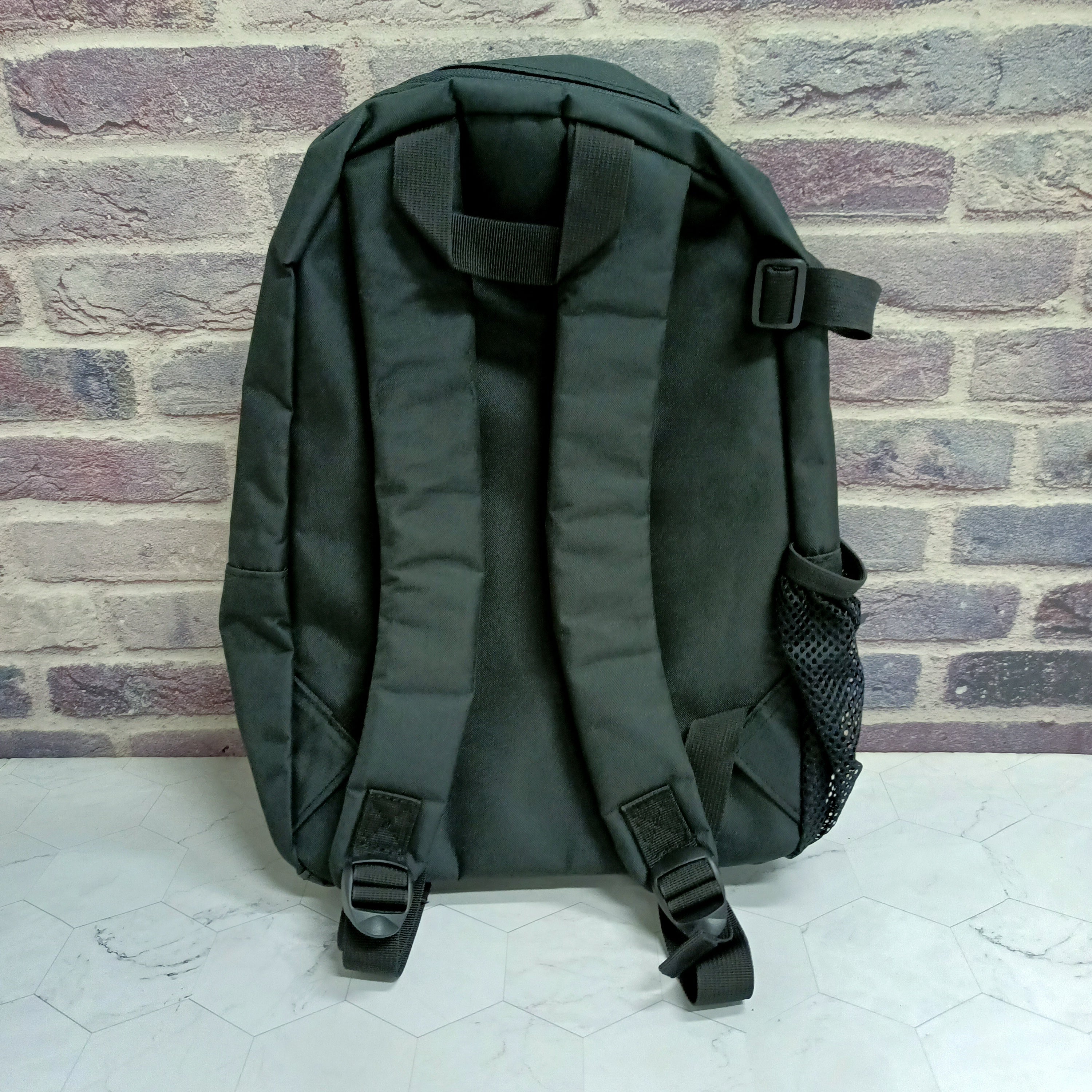 Black backpack back view with adjustable shoulder straps and top handle