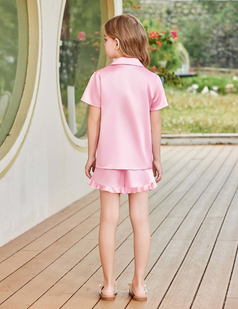 Back view: girls light pink satin pajama set with short sleeve top and ruffled hem shorts