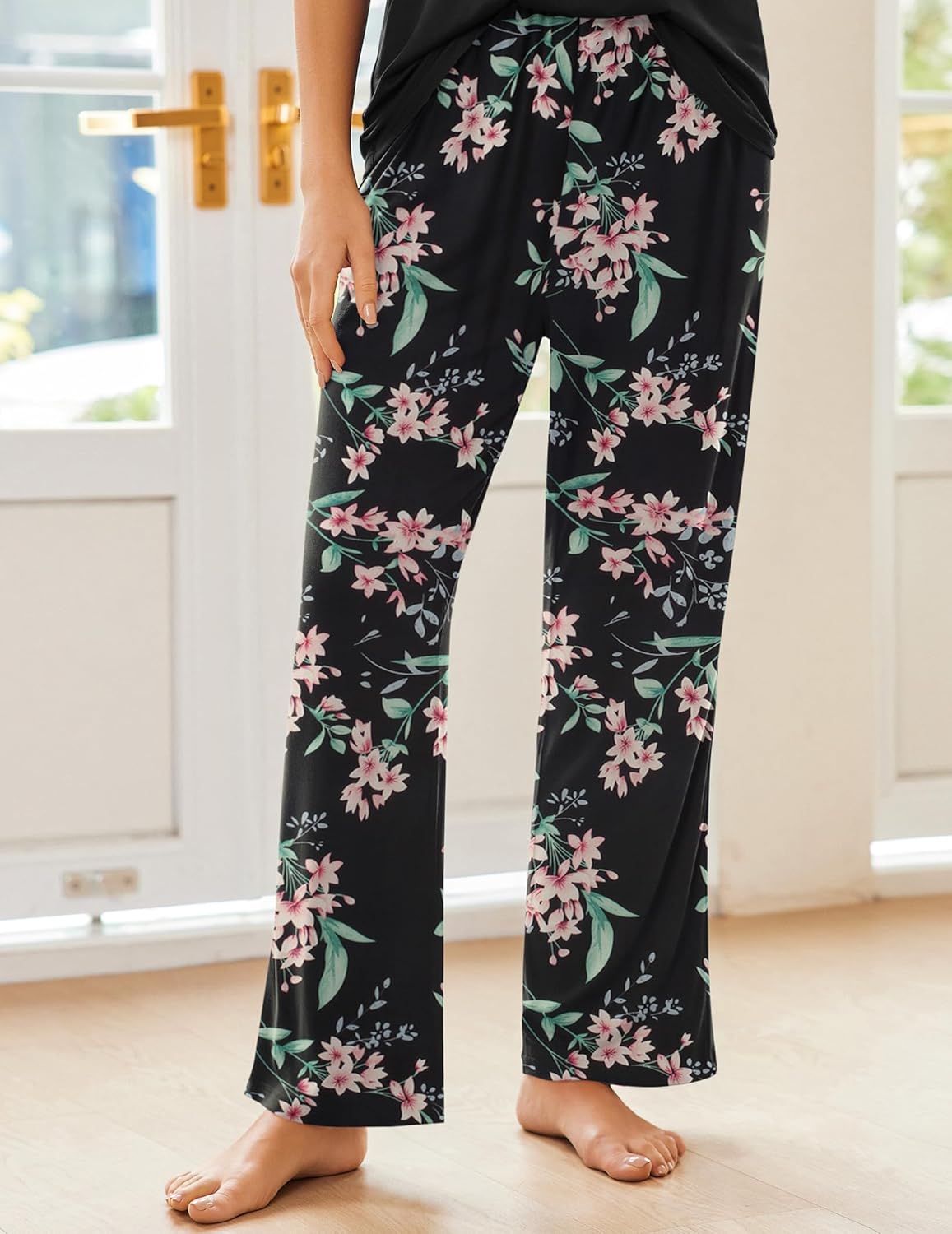 Floral pajama pants in black with pink-and-green blossoms, cropped front