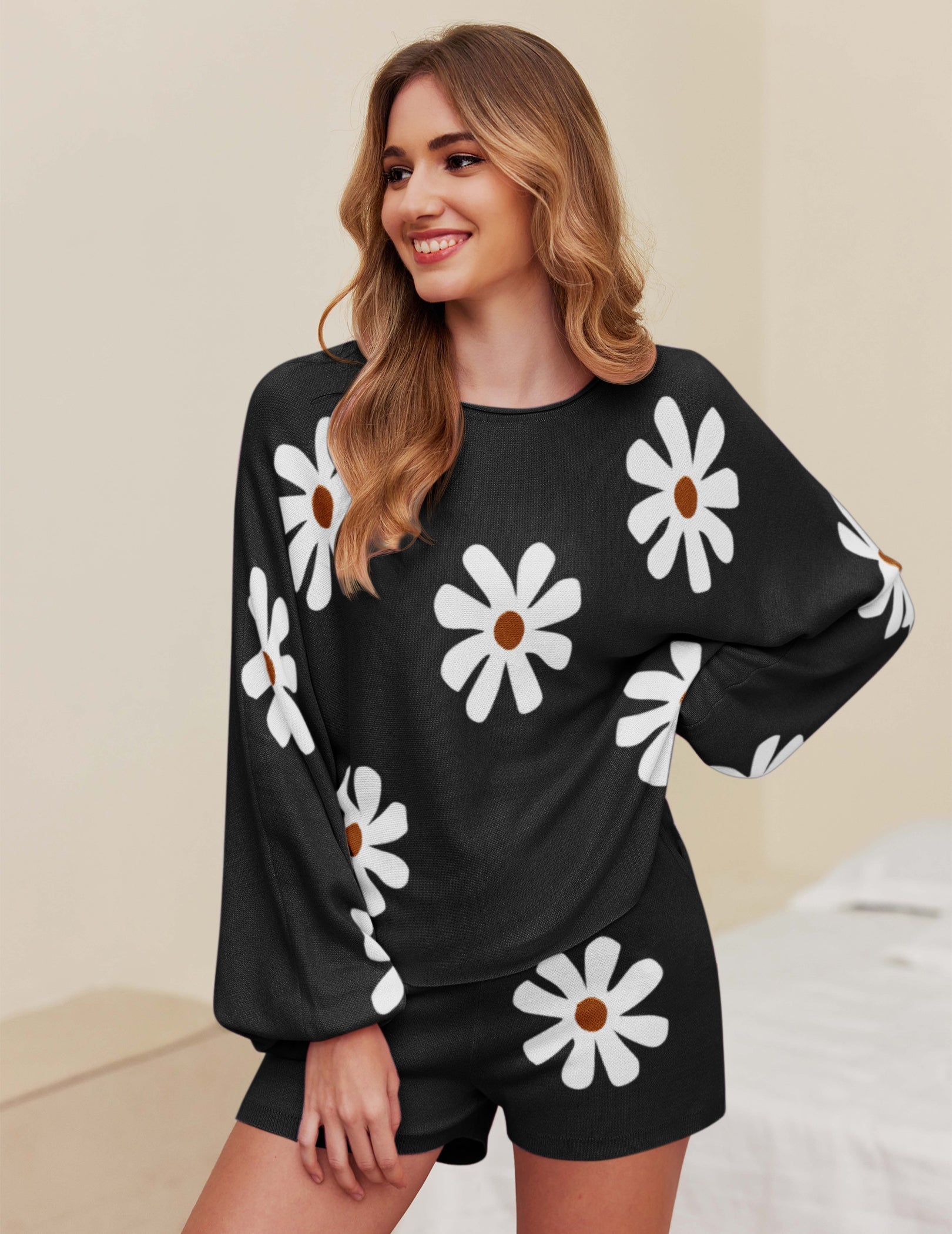 Black pajama set with white daisy print, long-sleeve top and matching shorts