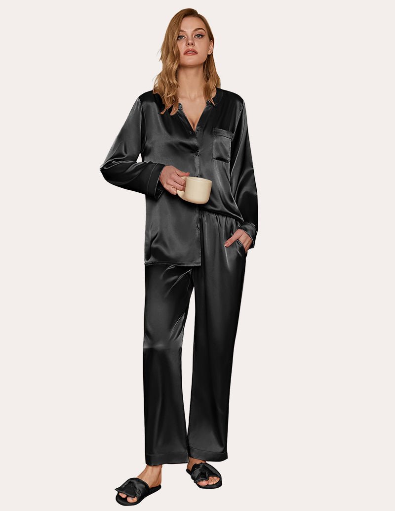Black satin pajama set with long sleeves, V-neck top, and matching wide-leg pants