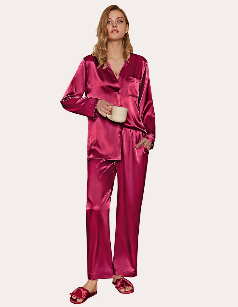Pink satin pajama set with long sleeves and button-down top, matching pants