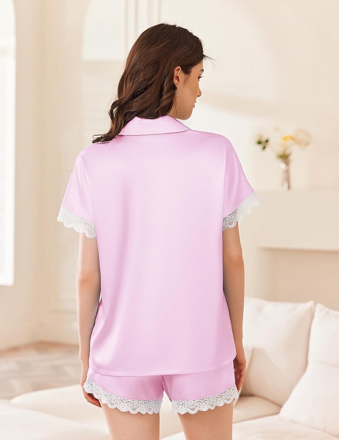Pink satin pajama set with lace-trimmed short sleeves and matching lace shorts